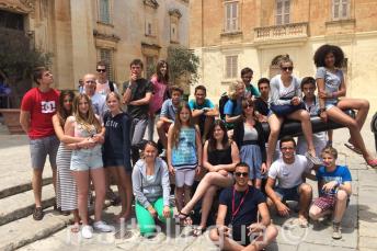 Estudantes sentados em um cânone em Mdina