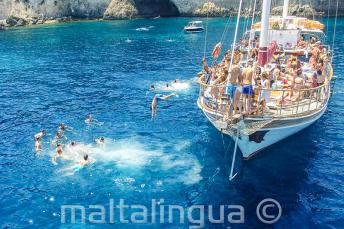 Alunos de inglês saltando do barco em Crystal Bay, Comino.