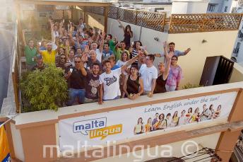 Alunos de inglês acenando no terraço da escola