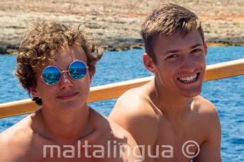 2 meninos sorrindo durante em uma viagem de barco escolar