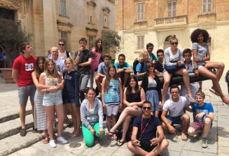 Estudantes sentados em um cânone em Mdina