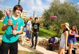 Alunos que jogam beisebol e frisbee no parque residencial