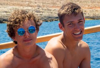 2 meninos sorrindo durante em uma viagem de barco escolar
