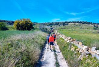 Um grupe de alunos de inglês camihando no campo em Malta